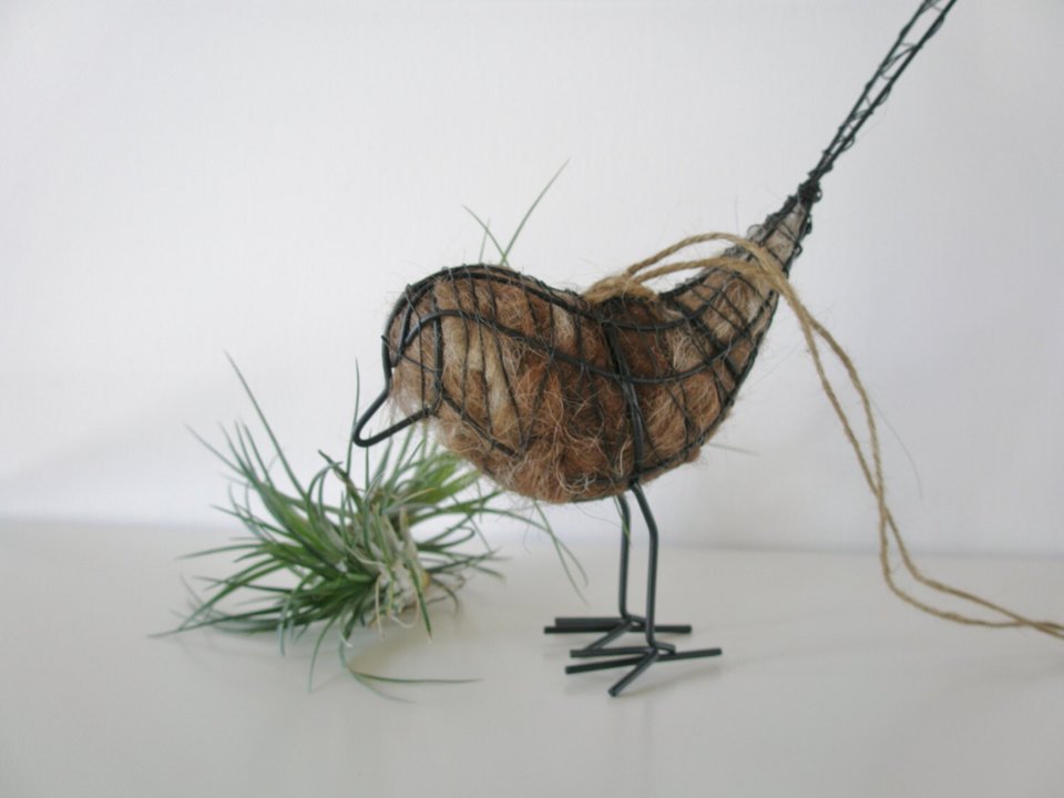 small wire bird filled with llama nesting fibre for birds to collect for nest building